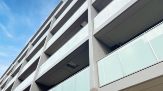 青空の下で見上げたマンションの外観。ブログ「引っ越しから1ヶ月、半身麻痺の私が前向きになれた理由」に関連する画像。