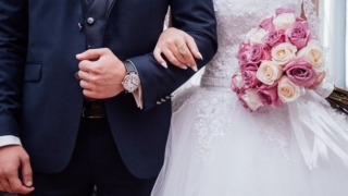 結婚式で手をつないでいる新郎新婦と花束