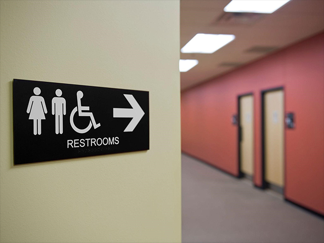車椅子対応トイレを示す案内標識と廊下の様子