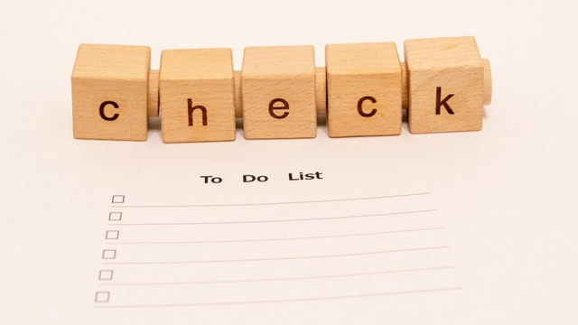 木製ブロックで「check」と表現された文字と未記入のTo Doリスト用紙の写真