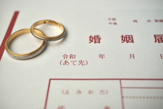 日本の婚姻届と2つの結婚指輪、結婚手続きや夫婦の誓いを象徴する写真