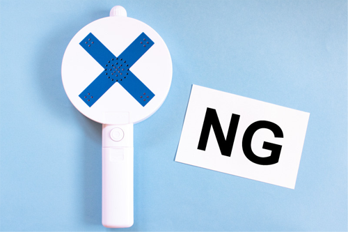 青いバツ印のついたサインと「NG」と書かれたカード、禁止や注意を表すイメージ。