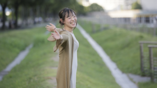 耳が聞こえない人の働き方や働きやすい職場環境をイメージした、屋外で笑顔で腕を広げる女性