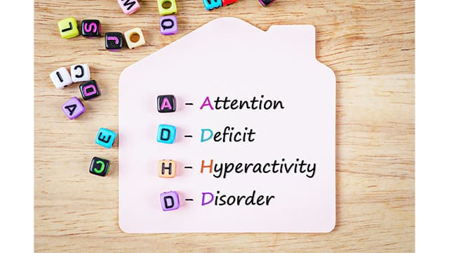 ADHD(注意欠如・多動症)の意味を示す「Attention Deficit Hyperactivity Disorder」の文字とカラフルなアルファベットブロックが並べられたイメージ写真