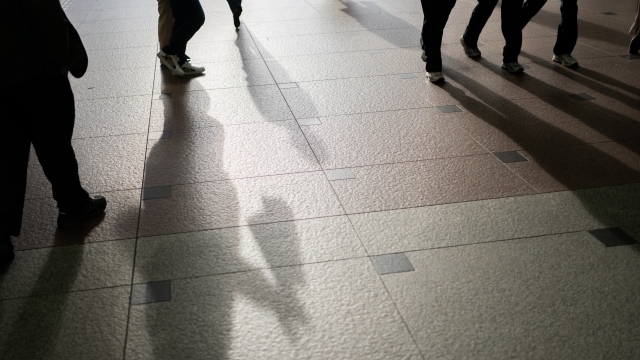 夕方の光に照らされながら街中を歩く人々の影。障害者として生きる覚悟と前を向く決意を象徴するイメージ。