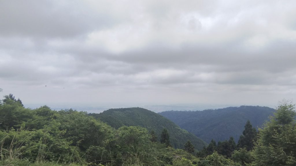 一日で22km歩いた山登りの途中、曇り空の下で山の稜線と連なる山々を見渡した景色