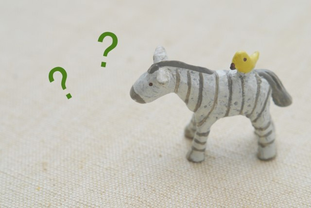 陰性症状とは何かを疑問に感じているイメージ。クエスチョンマークと置物で、陰性症状の分かりにくさを表している。