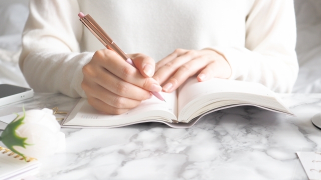 ストレスコントロールのためにノートへ書き出しを行い、疲れを溜めない方法を実践する女性の手元イメージ